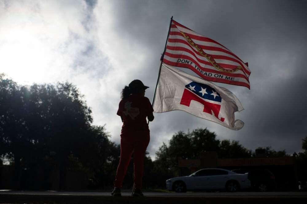 Republican supporter Dolly Schultz holds flags outside of a polling place at SSGT Willie de Leon Civic Center at the start of voting in Uvalde, Texas, on November 8, 2022. (Photo by Mark Felix / AFP) (Photo by MARK FELIX/AFP via Getty Images)