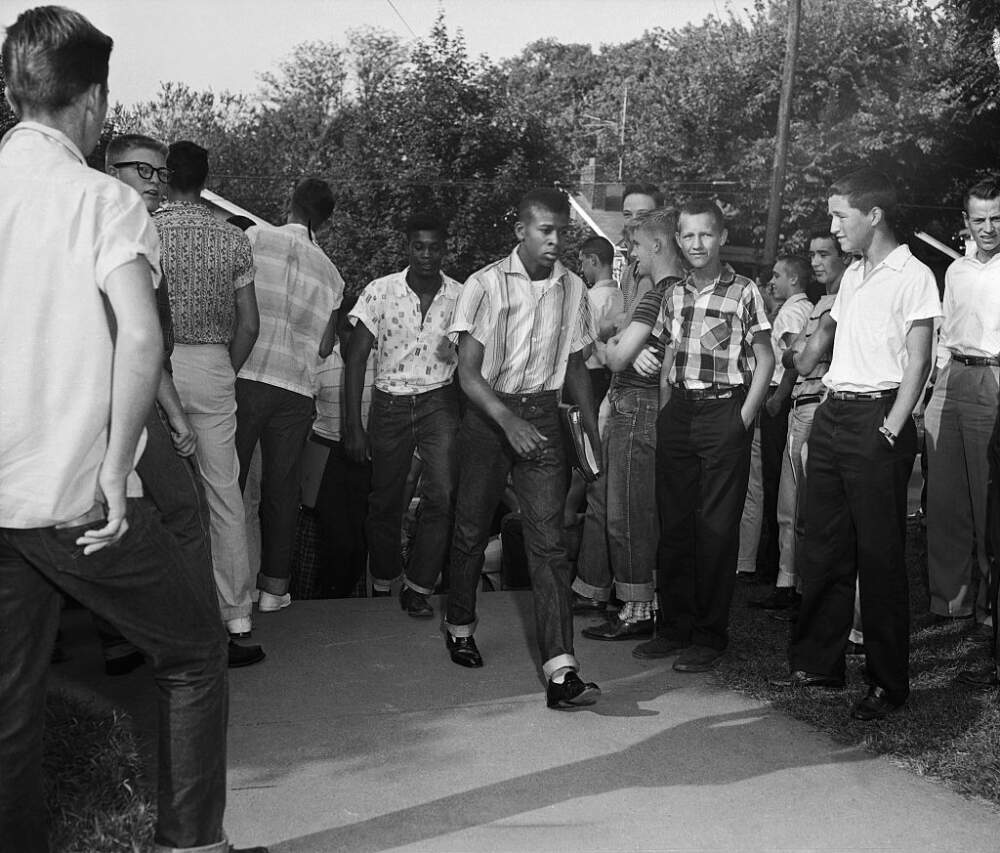 Black students walk through rows of white students to integrate Clinton High School. This went without incident, despite racial disturbances in the town prior to this.