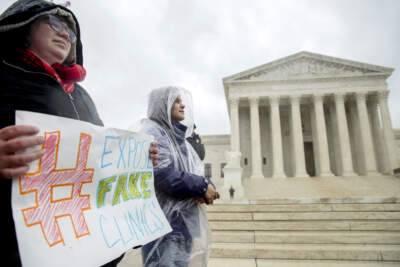 A pro-abortion rights supporter holds a sign that reads &quot;Expose Fake Clinics&quot; during a rally outside the Supreme Court in Washington, Tuesday, March 20, 2018, as the Supreme Court hears arguments in a free speech fight over California's attempt to regulate anti-abortion crisis pregnancy centers. (AP Photo/Andrew Harnik)