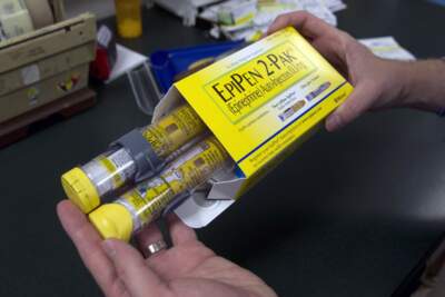 A pharmacist displays a package of EpiPens, an epinephrine autoinjector for the treatment of allergic reactions. (Rich Pedroncelli/ AP)