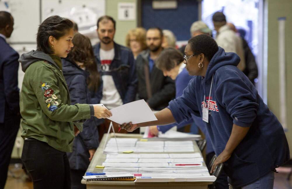 A voter receives a ballot at Graham and Parks School in Cambridge, Mass. in 2020. (Robin Lubbock/WBUR)
