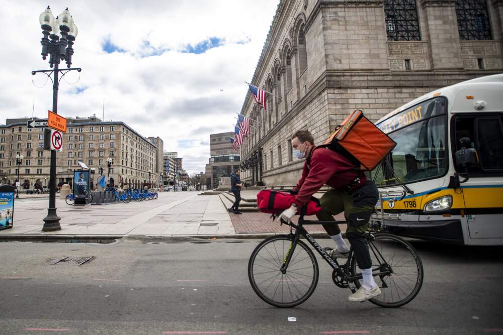 A food delivery bike courier rides down Boylston Street during the lunch hour. (Jesse Costa/WBUR)