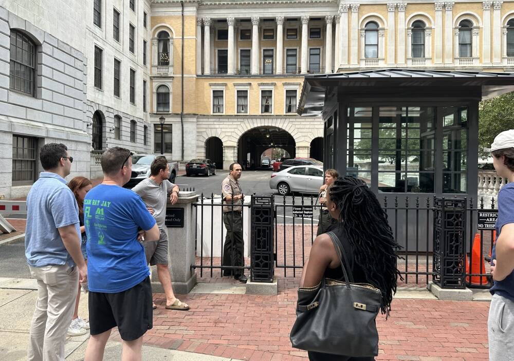 State House staff queue outside the Bowdoin Street gate, waiting for escorted trips into their offices to collect their belongings, the morning after a sudden evacuation on July 18, 2023. (Sam Doran/SHNS)