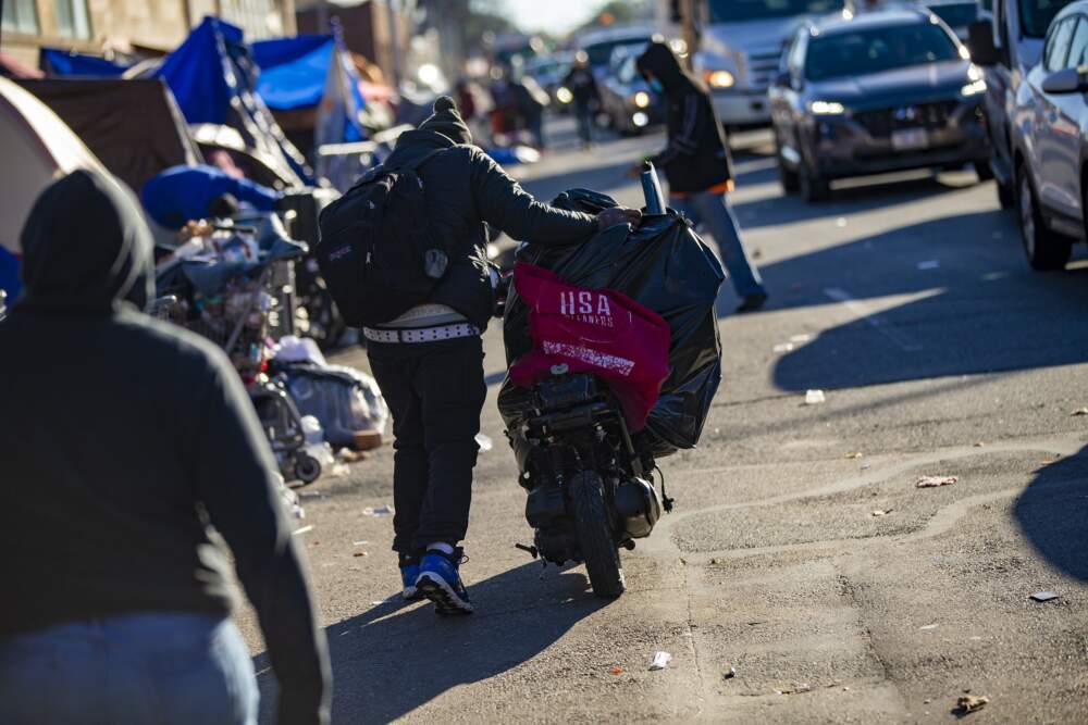 A man walks his scooter loaded with his belonging down Southampton Street in the &quot;Mass. and Cass&quot; area in 2021. (Jesse Costa/WBUR)