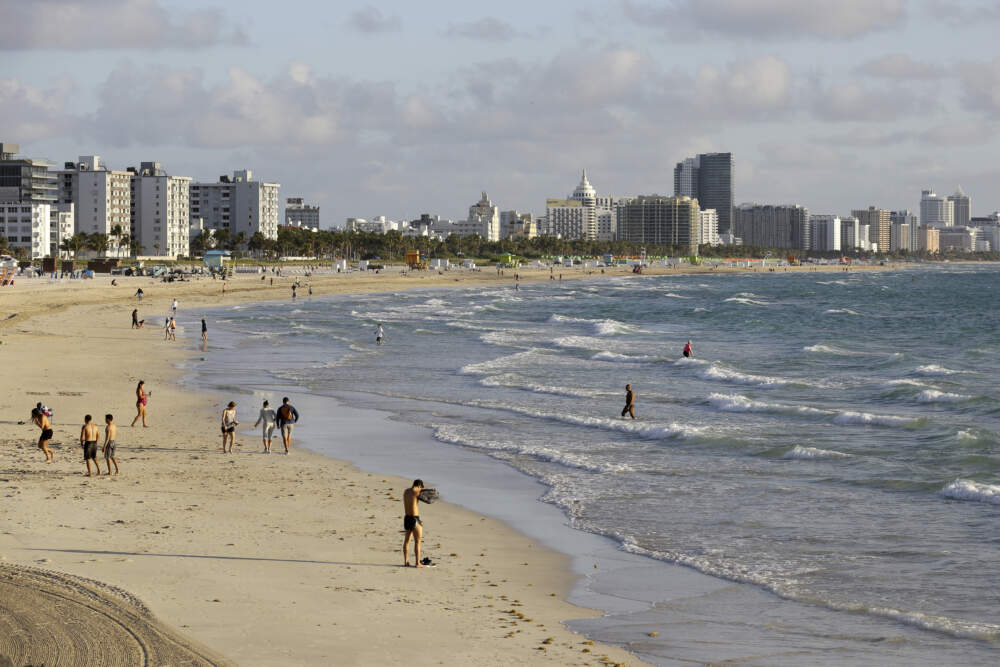 Beach goers walk along South Beach in Miami. (Lynne Sladky/AP)