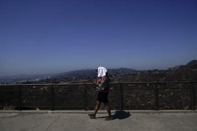 Tekosha Seals, a tourist visiting from Georgia, walks with a tower over her head at the Griffith Observatory in Los Angeles during a heat wave. (Jae C. Hong/AP)