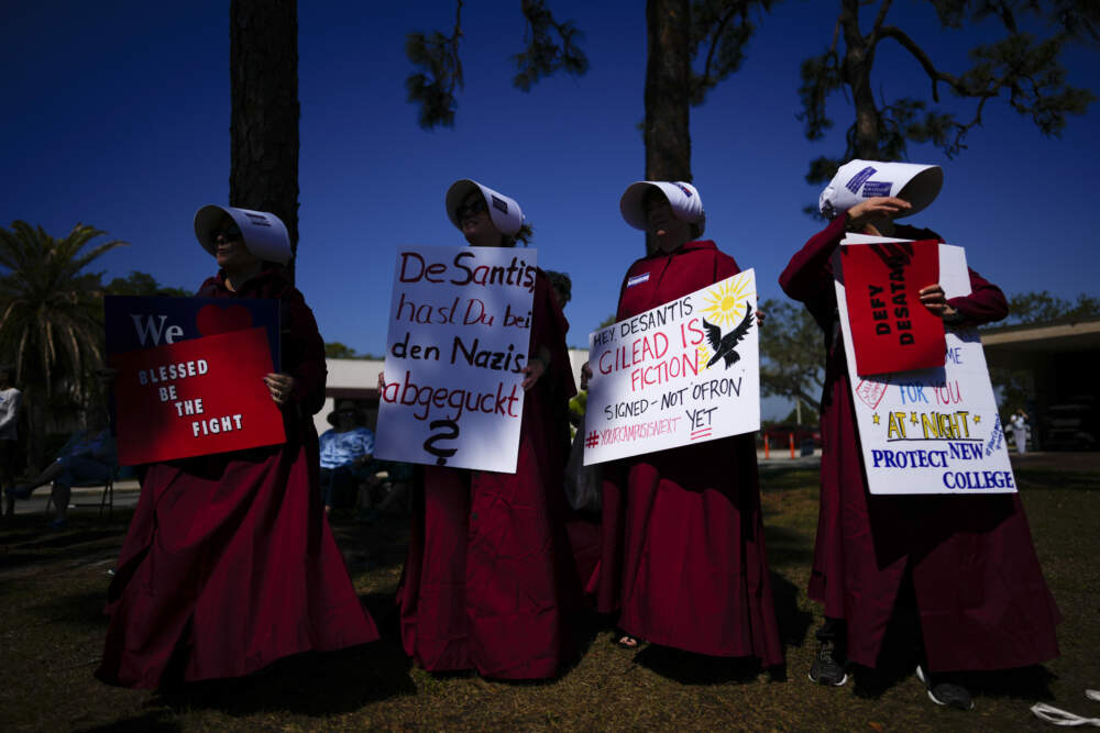 Joyce White, center left, whose daughter Lola is a third-year biology major at New College of Florida, protests along with other parents dressed as handmaids from Margaret Atwood's &quot;The Handmaid's Tale,&quot; ahead of a meeting by the college's board of trustees, Tuesday, Feb. 28, 2023, on the school's campus in Sarasota, Fla. (Rebecca Blackwell/AP)