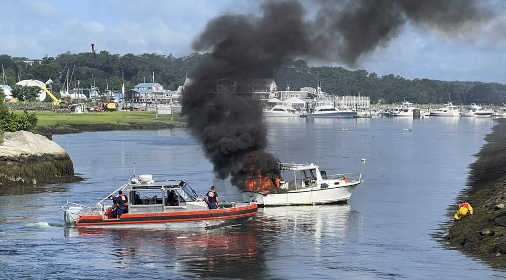 A boat caught fire in Gloucester. Firefighters rescued two people from the water. (Gloucester Fire Department via AP)