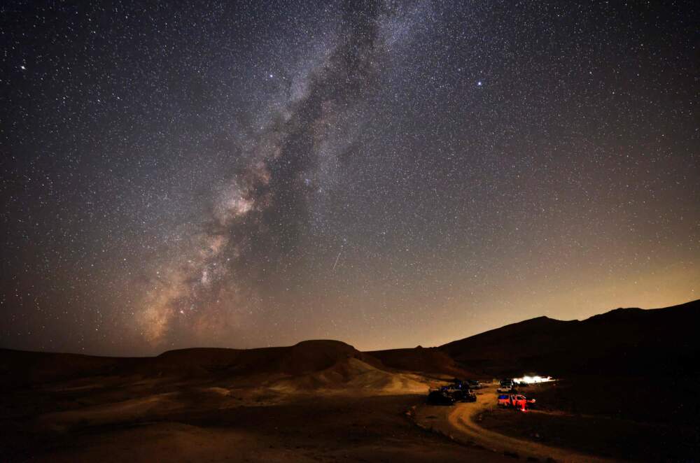 The Milky Way galaxy is pictured as a Perseid meteor streaks across the sky above the Negev desert near the Israeli city of Mitzpe Ramon, on August 12, 2021, during a yearly meteor shower, which occurs when the earth passes through the cloud of debris left by the comet Swift-Tuttle. (Menahem Kahana/AFP via Getty Images)