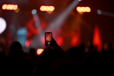 A fan records a concert on a cell phone. (Stephen Maturen/Getty Images for iHeartRadio)