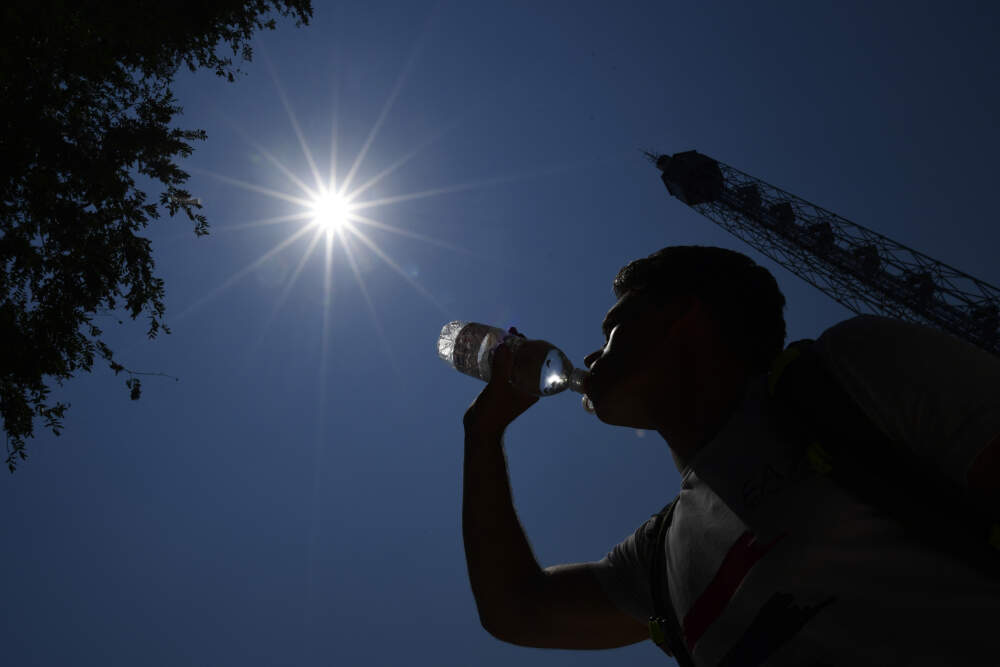 A man drinks water during a hot summer day. (Photo by Miguel Medina/AFP via Getty Images)