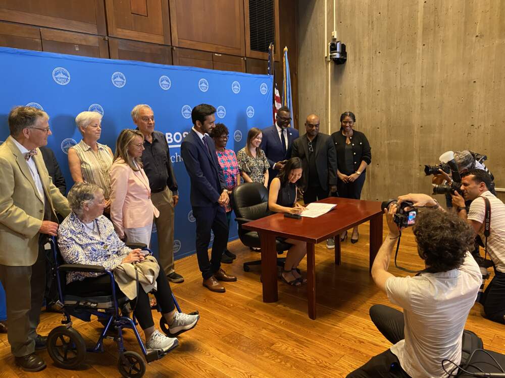 Boston Mayor Michelle Wu signs an executive order banning fossil fuels in new city buildings and major renovations. (Walter Wuthmann/WBUR)