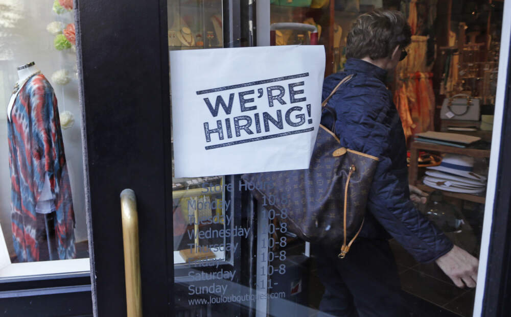 A woman passes a &quot;We're Hiring!&quot; sign while entering a clothing store in the Downtown Crossing of Boston, May 18, 2016. (Charles Krupa/AP)