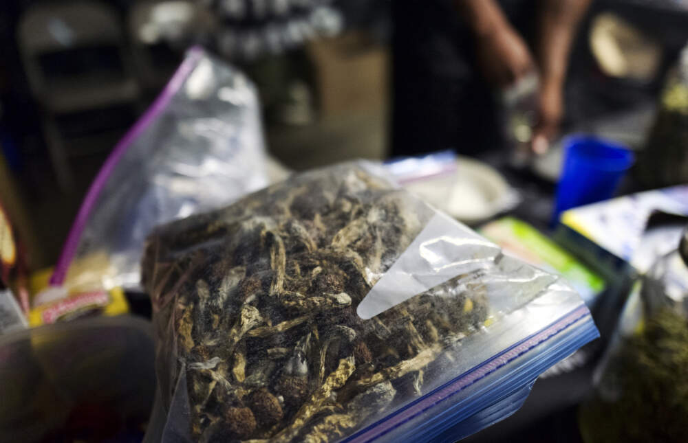A vendor bags psilocybin mushrooms at a pop-up cannabis market in Los Angeles. (Richard Vogel/AP)