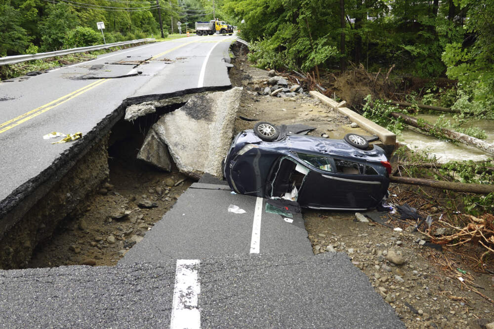 A damaged car lays on a collapsed roadway along Route 32 in the Hudson Valley near Cornwall, N.Y., Monday, July 10, 2023. Heavy rain has washed out roads and forced evacuations in the Northeast as more downpours were forecast throughout the day. (Paul Kazdan/AP)