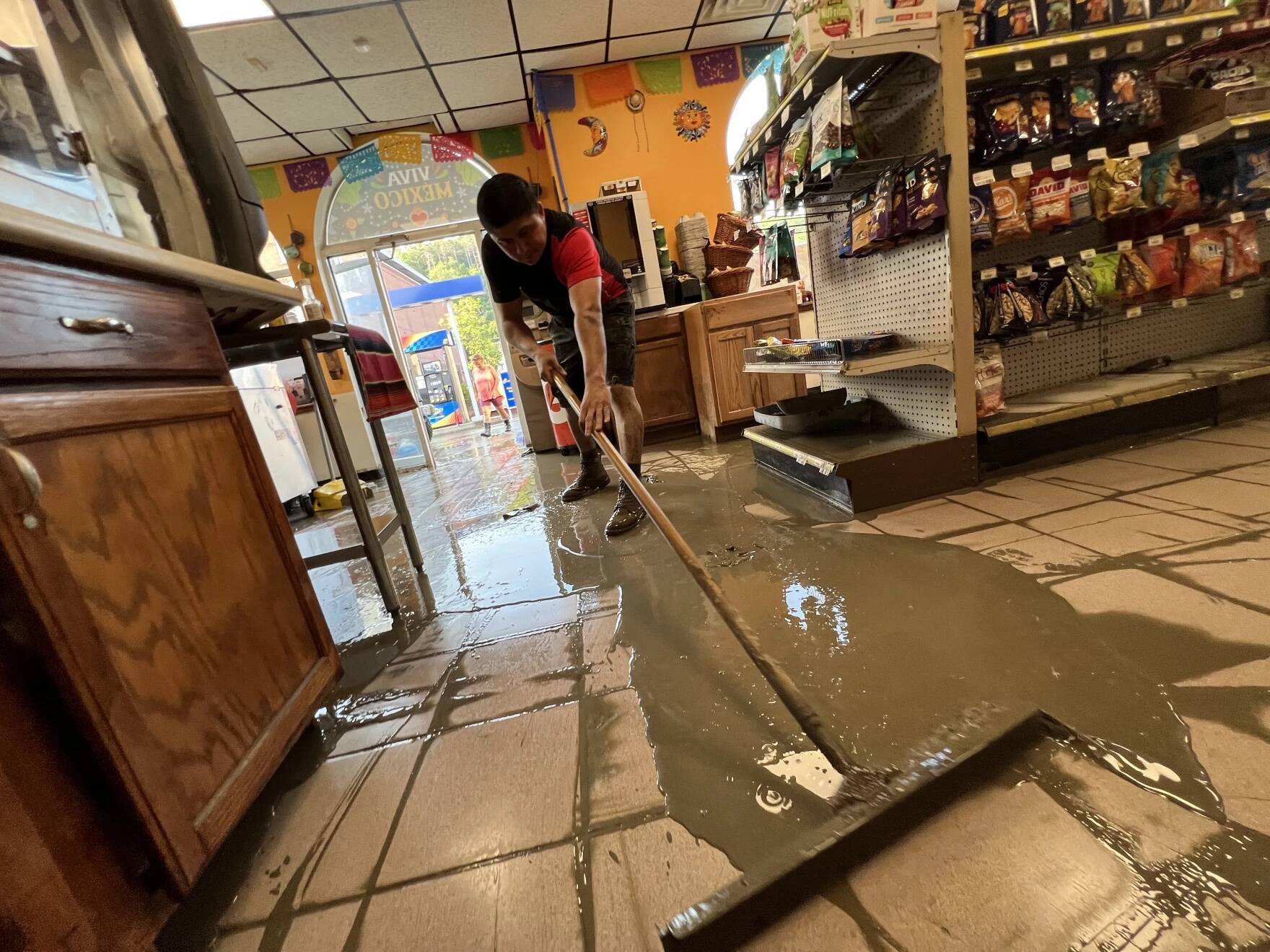 An employee at Arandas Mexican Cuisine in Montpelier on Tuesday evening cleans up mud left behind by the flood waters. (Brian Stevenson And Kyle Ambusk/ Vermont Public)