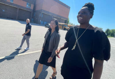 Mayor Michelle Wu, center, and Del Stanislaus, right, Boston Public Schools chief of capital planning, outside the West Roxbury Educational Complex on Monday, July 31, 2023. (Max Larkin/WBUR)