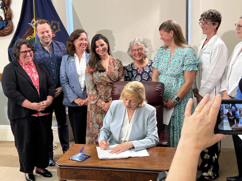 Gov. Janet Mills on July 19, 2023 signs into law a bill that allows abortions late in a pregnancy in Maine when a doctors says the procedure is medically necessary. (Kevin Miller/Maine Public)