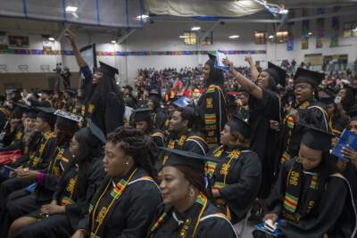 Roxbury Community College graduates cheer during one of the speeches given at the commencement.  (Jesse Costa/WBUR)