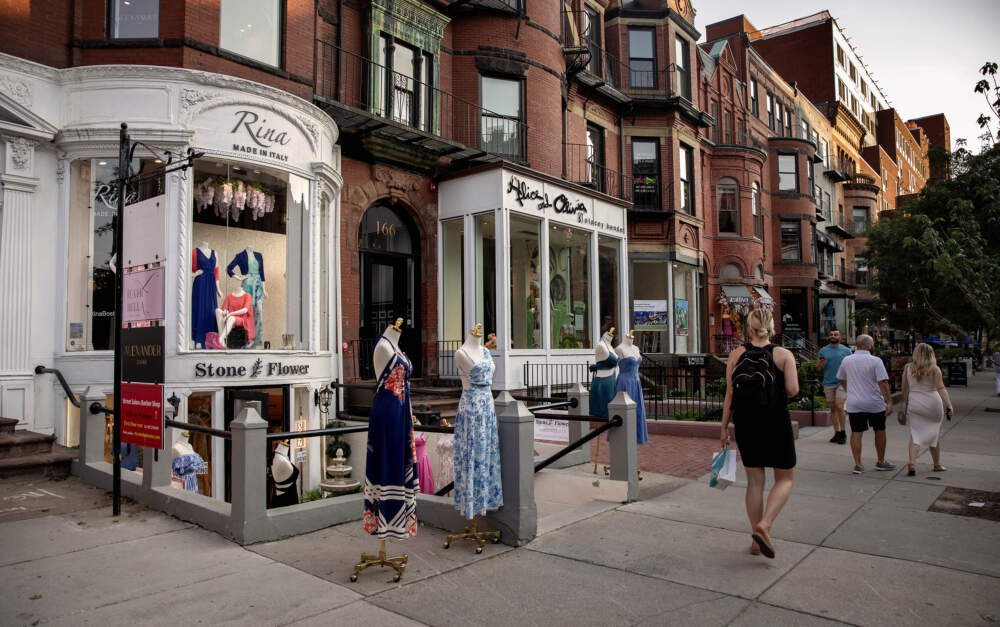 Pedestrians glance at store mannequins on a summer evening on Newbury Street in Boston's Back Bay. (Robin Lubbock/WBUR)