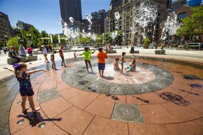 Children play in the Rings Fountain at the Greenway on a hot day. (Jesse Costa/WBUR)