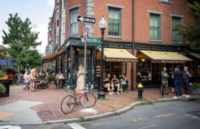 People fill seats and tables outside the South End Buttery on Shawmut Avenue in Boston. (Robin Lubbock/WBUR)