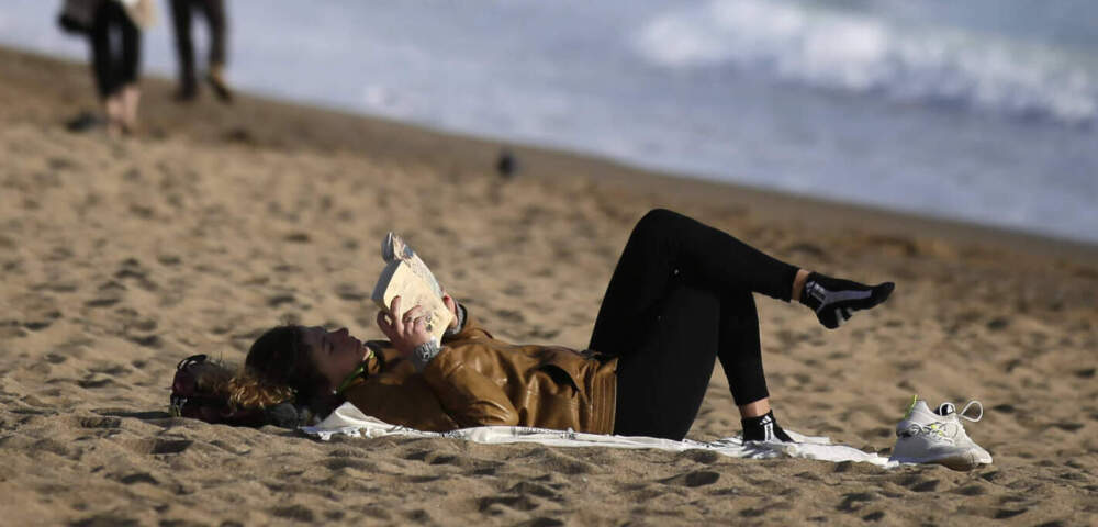A woman reads a book at the beach. (Manu Fernandez/AP)