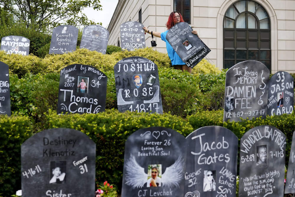 Jayde Newton helps to set up cardboard gravestones with the names of victims of opioid abuse outside the courthouse where the Purdue Pharma bankruptcy is taking place. (Seth Wenig/AP)
