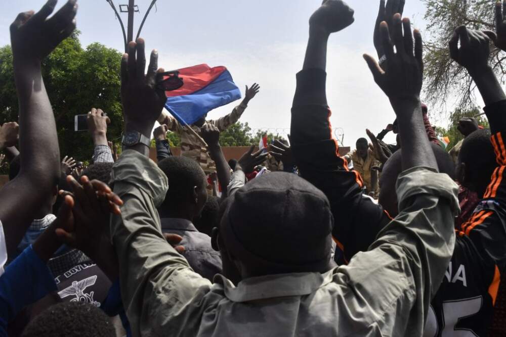 Protesters cheer Nigerien troops as they gather in front of the French Embassy in Niamey during a demonstration that followed a rally in support of Niger's junta in Niamey on July 30, 2023. Thousands of people demonstrated in front of the French embassy in Niamey on Sunday, before being dispersed by tear gas, during a rally in support of the military putschists who overthrew the elected president Mohamed Bazoum in Niger. Before the tear-gas canisters were fired, a few soldiers stood in front of the embassy to calm the demonstrators. (Photo by AFP) (Photo by -/AFP via Getty Images)