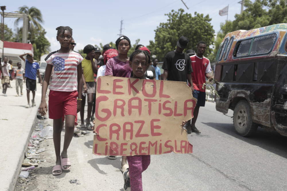 A girl carries a sign that reads in Creole &quot;Free school is broken. Release the nurse,&quot; during a march to demand the freedom of New Hampshire nurse Alix Dorsainvil and her daughter, who have been reported kidnapped, in the Cite Soleil neighborhood of Port-au-Prince, Haiti, Monday, July 31, 2023. (Odelyn Joseph/AP)