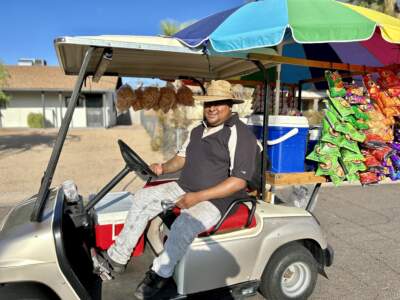 Street vendor Lauro Ilario drives a golf cart through Phoenix neighborhoods to sell snacks and snow cones. He says the recent heatwave has cost him thousands of dollars because his customers aren't going outside. (Peter O'Dowd/Here & Now)
