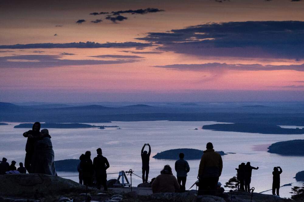 Early-rising visitors to Acadia National Park await the sunrise on the summit of Cadillac Mountain. (Robert F. Bukaty/AP)