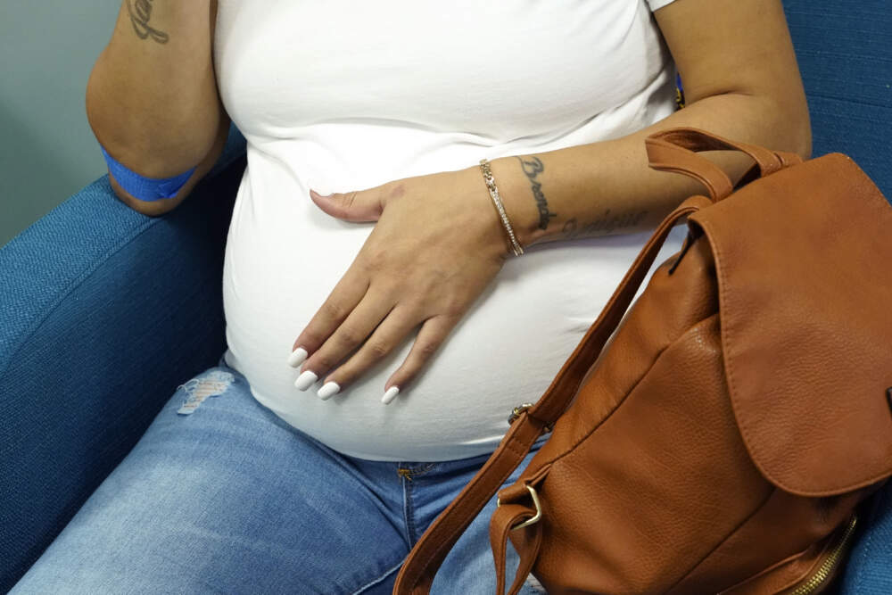 A mother rubs her stomach before meeting with a midwife in Jackson, Miss., clinic that serves pregnant women, Dec. 17, 2021. (Rogelio V. Solis/AP)