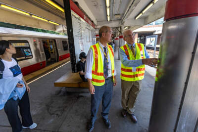 General Manager and CEO, Philip Eng, and the MBTA’s newly hired Chief of Stations, Dennis Varley examine a column during a visit to JFK/UMASS station in Dorchester. (Jesse Costa/WBUR)