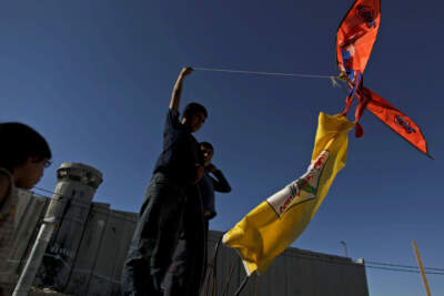 Palestinian children play with a kite next to a portion of Israel's separation barrier in the West Bank refugee camp of Aida in Bethlehem, Thursday, June 10, 2010. (Tara Todras-Whitehill/AP)