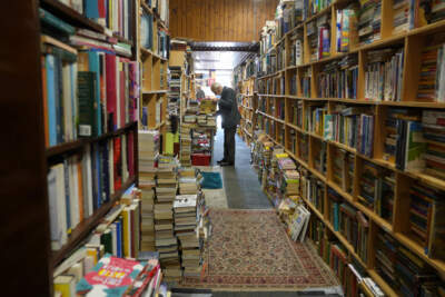 A man browses through the pages of a book at a second hand book store in Belfast, Tuesday, Sept. 13, 2022. (AP Photo/Gregorio Borgia)