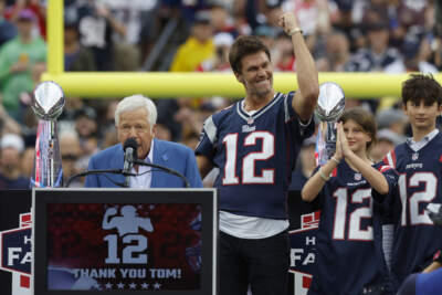 Former New England Patriots quarterback Tom Brady gestures as Patriots owner Robert Kraft, left, addresses the crowd while Brady's daughter Vivian, second from right, and son Benjamin, right, look on during halftime ceremonies held to honor Brady at an NFL football game between the Philadelphia Eagles and the Patriots, Sunday, Sept. 10, 2023, in Foxborough, Mass. (Mark Stockwell/AP)