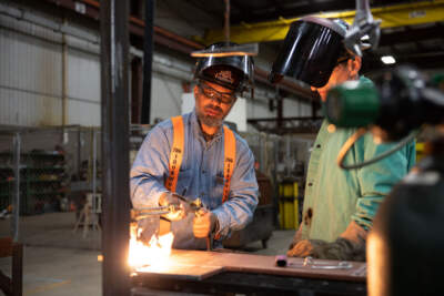Simon Denby, a 49 year old apprentice instructor, helps a student at Ironworkers local 29 steel work in Dayton, Ohio, on October 24, 2022. - In the face of the rising prices that are crushing this election campaign, Joe Biden is hammering home his message: the tens of billions of dollars voted on by the Democrats will revive American manufacturing and its &quot;good-paying jobs.&quot; He is trying to reconnect with the white working class, which has been largely lost to a Democratic Party that has long supported free trade. But in Ohio, where Donald Trump came out on top in the last two presidential elections, inflation and a deep sense of disenfranchisement are hampering this strategy. (Photo by Megan JELINGER / AFP) (Photo by MEGAN JELINGER/AFP via Getty Images)