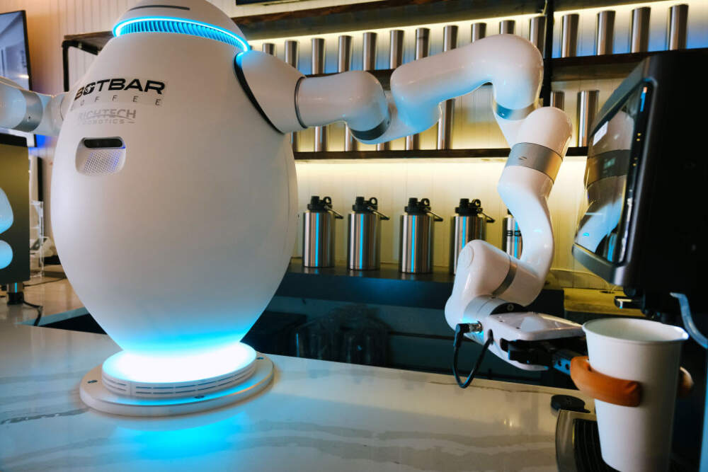 A two-armed robot called &quot;ADAM&quot; prepares a cup of coffee for a customer at Botbar coffee shop on May 31, 2023 in Brooklyn, New York. (Spencer Platt/Getty Images)