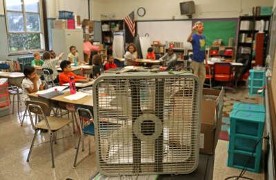 Teacher John Barry uses a fan to cool off his fourth grade classroom at the Mary Curley K-8 school in Jamaica Plain on the first day of school in 2016.  (David L. Ryan/The Boston Globe via Getty Images)
