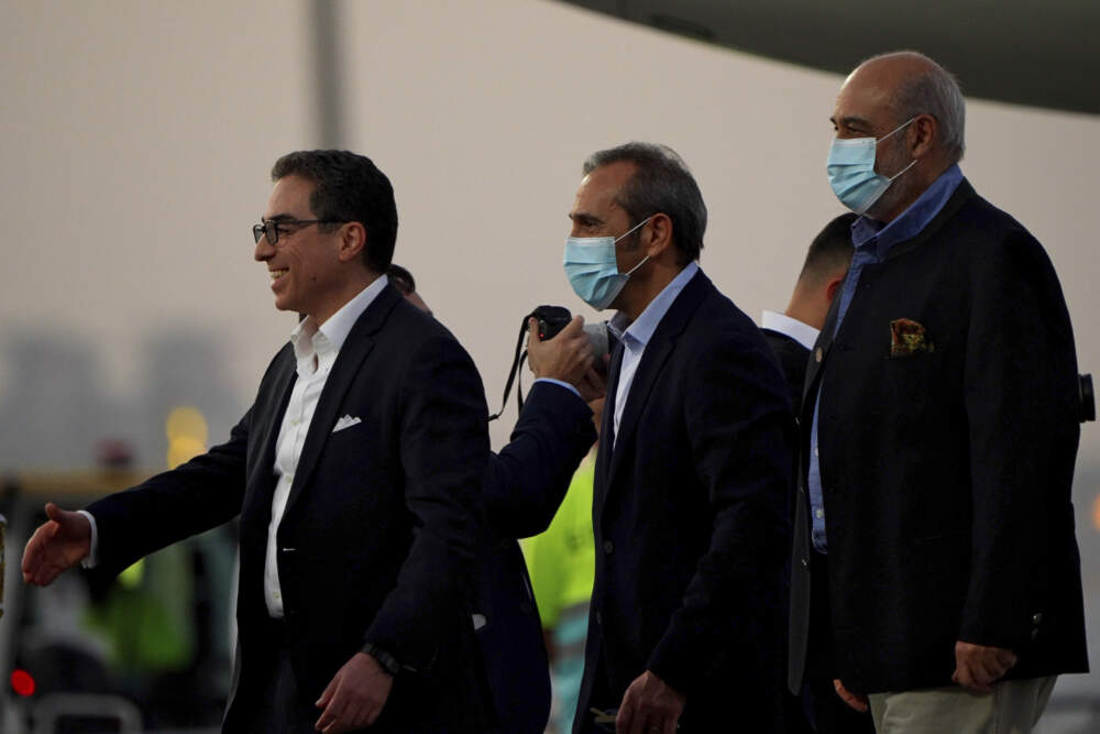 From left, Siamak Namazi, Emad Sharghi and Morad Tahbaz walk away from a Qatar Airways flight that brought them out of Tehran and to Doha, Qatar, Monday, Sept. 18, 2023. (Lujain Jo/AP)