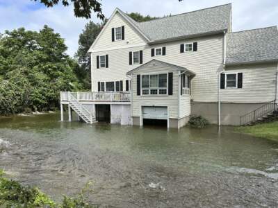 A brook in Leominster, Mass. overflows into the garage of a home following heavy rains overnight, Tuesday, Sept. 12, 2023. (Michael Casey/AP)