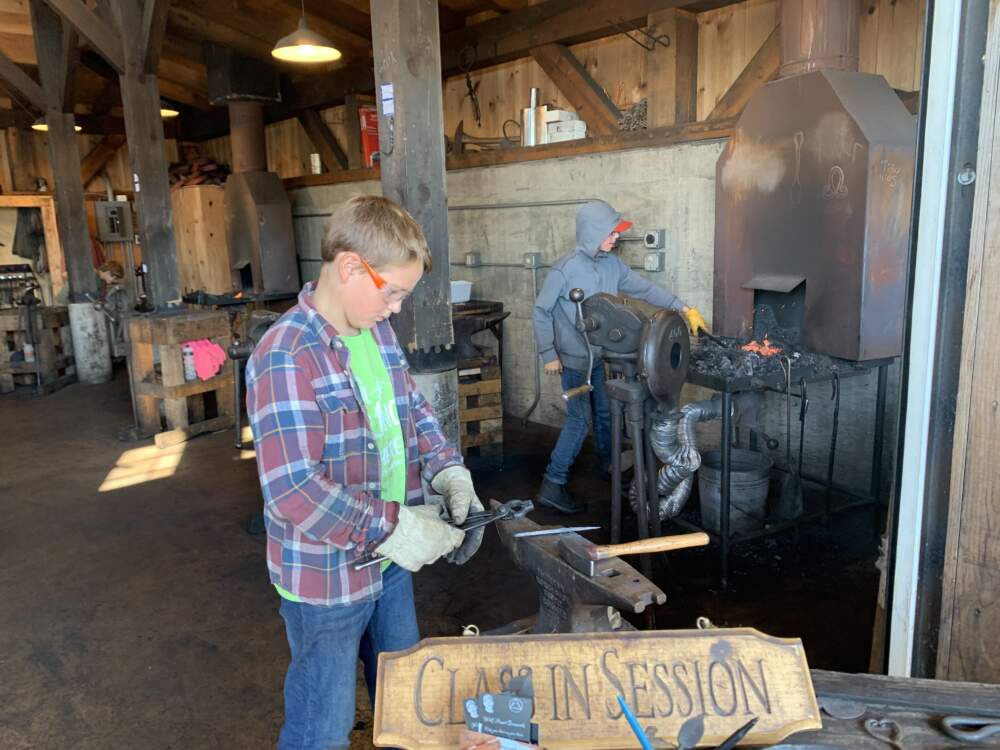 Young students in the blacksmith shop at the North House Folk School in Grand Marais, MN. (Jon Kalish)