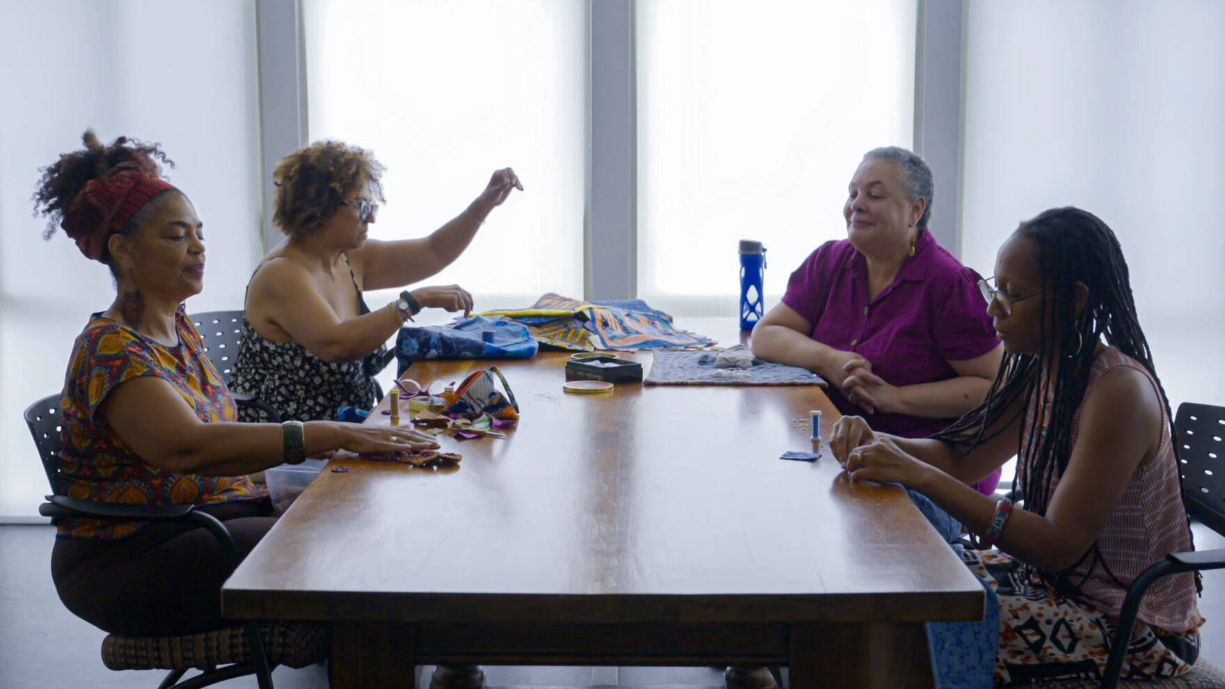 From left, Christle Rawlins-Jackson, Donna Clark, Susi Ryan and Kimberly Love Radcliffe work on quilts during a meeting of Sisters in Stitches Joined by the Cloth, August 10, 2023, in Worcester, Massachusetts. (Ryan Caron King/Connecticut Public)