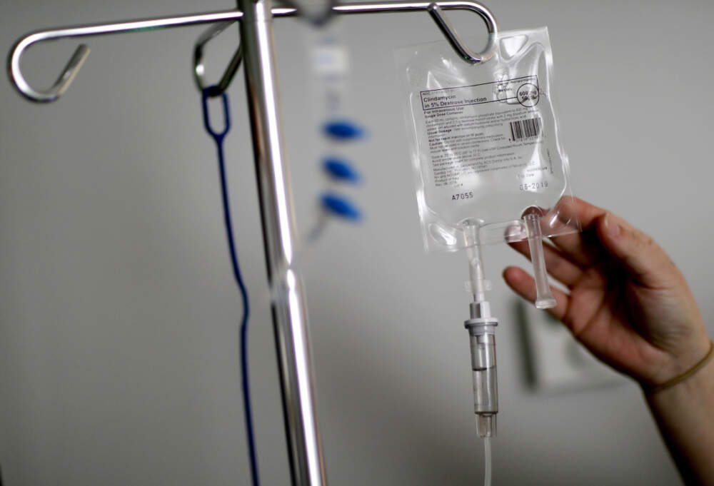 A nurse hooks up an IV to a flu patient. (David Goldman/AP)