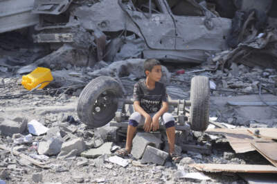 A Palestinian boy sits on the rubble of his building destroyed in an Israeli airstrike in Nuseirat camp in the central Gaza Strip on Monday, Oct. 16, 2023. (Hatem Moussa/AP)