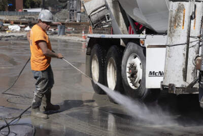 A worker cleans a cement truck at a construction site in Boston. (Michael Dwyer/AP)