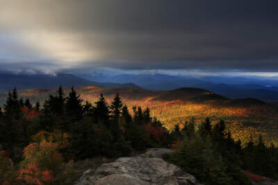 Fall foliage colors line the mountains in Chatham, New Hampshire under a gray sky. (Robert F. Bukaty/AP)