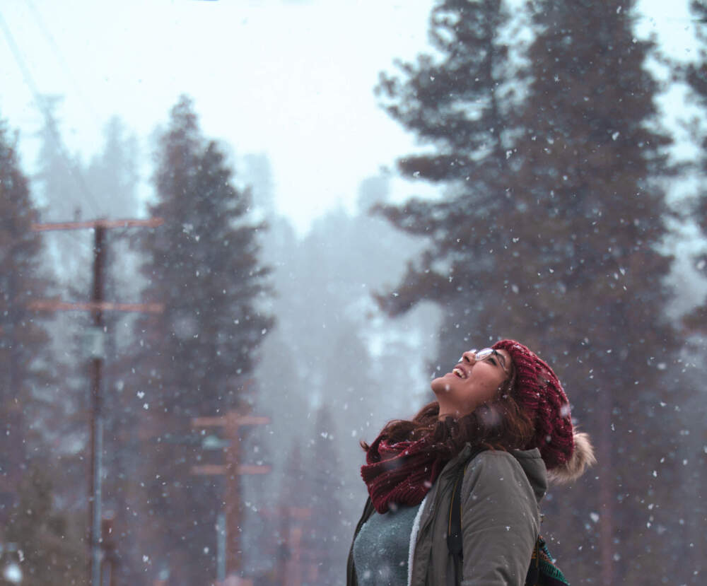 A young woman enjoys the recent snowfall (Getty Images)