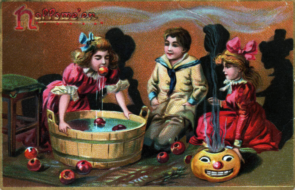 A Halloween scene with children bobbing for apples is printed on this Tuck postcard from early 20th century published in London, England. (Transcendental Graphics/Getty Images)